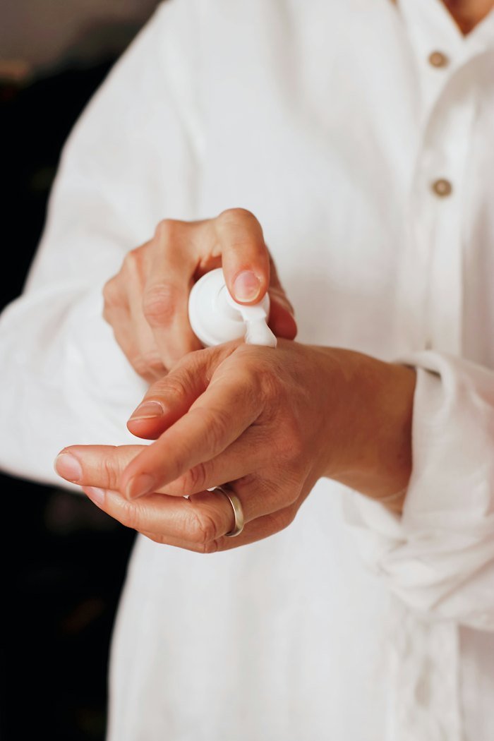 Hands applying body care lotion