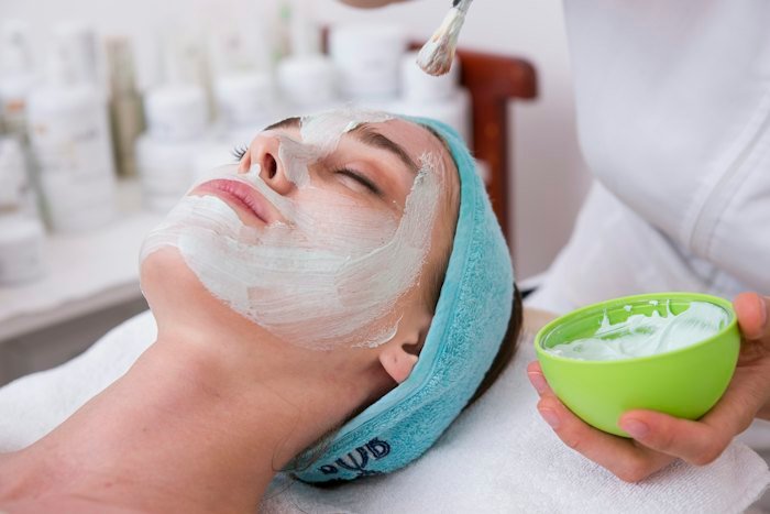 Woman with a hydrating face mask during a spa treatment